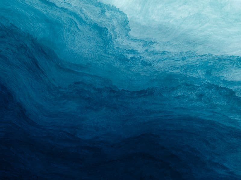 Aufgewühlte Welle in tiefem Blau